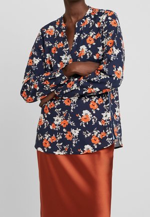 Bloemige blouse met lange mouwen in marineblauw, met oranje en witte bloemen, voorzien van een mandarin collar en een rechte snit met zijsplitten.