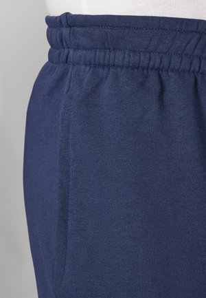 Marineblauwe joggingbroek met elastische tailleband en zijnaadzak, getoond op een wit paspoptorso.
