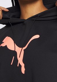 Felpa nera con cappuccio e un grande logo rosa di Puma sul davanti. Presenta stringhe per il cappuccio e un tessuto testurizzato per il comfort.