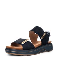 Marineblaue Wildledersandalen mit zwei breiten Riemen, einem beigen gepolsterten Fußbett und einer niedrigeren Wedge-Sohle mit einem goldenen Akzent in der Nähe des Riemens.