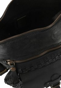 Borsa in pelle nera con superficie testurizzata, zip metallica e dettaglio intrecciato nella parte anteriore inferiore; l'interno è scuro, con una fodera liscia.