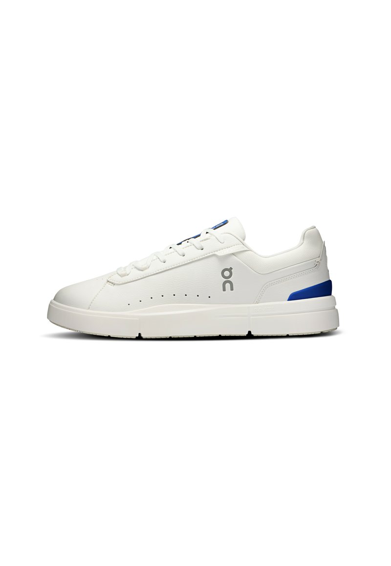 Baskets de sport blanches en matériau synthétique, avec un design perforé, des accents bleus et une semelle plate en caoutchouc.
