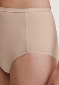 Nude hoge taille slip gemaakt van gladde, rekbare stof. Heeft schone stiksels en een naadloos ontwerp voor een comfortabele pasvorm.