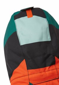 Giacca multicolore con sezioni verdi, nere, azzurro chiaro e arancione. Texture liscia con cuciture visibili e un dettaglio ad anello arancione.