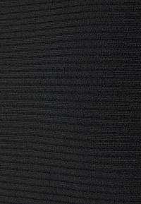 Tissu côtelé noir, finement texturé. Le matériau présente des lignes verticales régulières avec une finition lisse et une apparence douce.