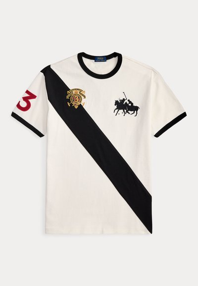 Λευκό κοντομάνικο πόλο πουκάμισο με μαύρη διαγώνια ρίγα, μαύρο γιακά και άκρες μανικιών, κόκκινο νούμερο 3 στο μανίκι και λογότυπα παίκτη πόλο στο στήθος.