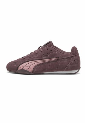 Sneaker in suede viola con striscia rosa curva, chiusura con lacci, dettagli traforati e suola piatta in gomma, vista laterale su sfondo bianco.