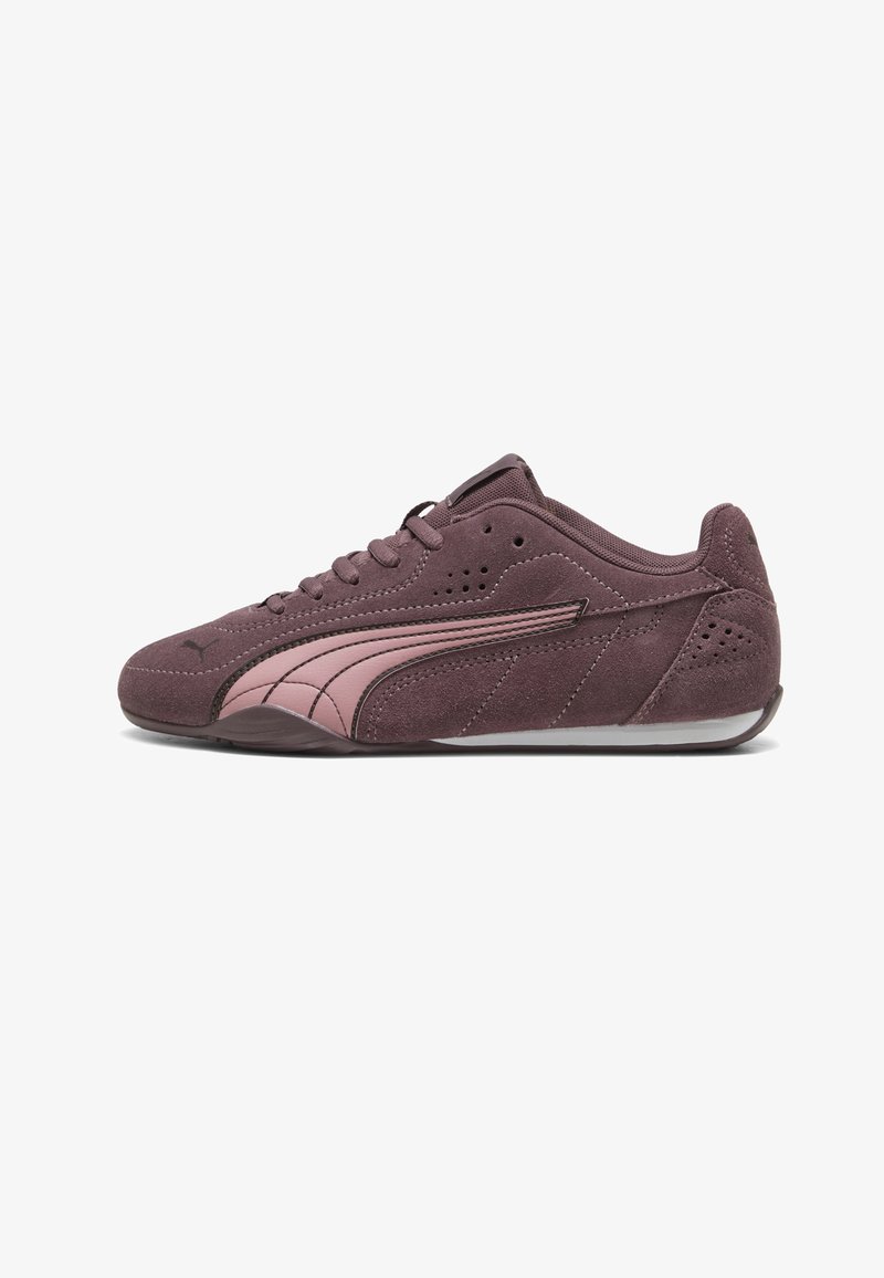 Basket en daim violet avec bande rose incurvée, fermeture à lacets, détails perforés et semelle plate en caoutchouc, vue de côté sur fond blanc.