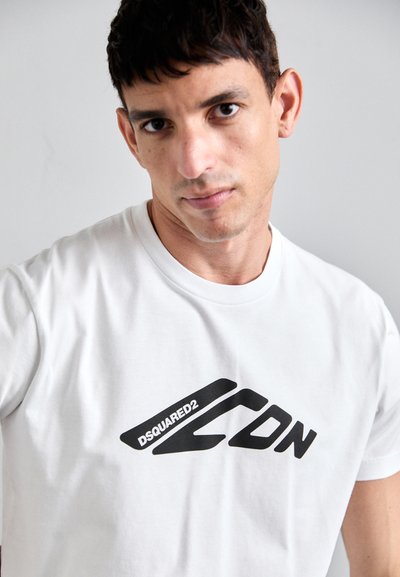White cotton t-shirt featuring a prominent black graphic logo with stylized text "DSQUARED2 CDN" on the front. Classic crew neck design.