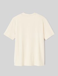 T-shirt à manches courtes en crème clair, fabriqué en tissu doux, avec un col rond et une coupe décontractée, sans motifs ni accents visibles.