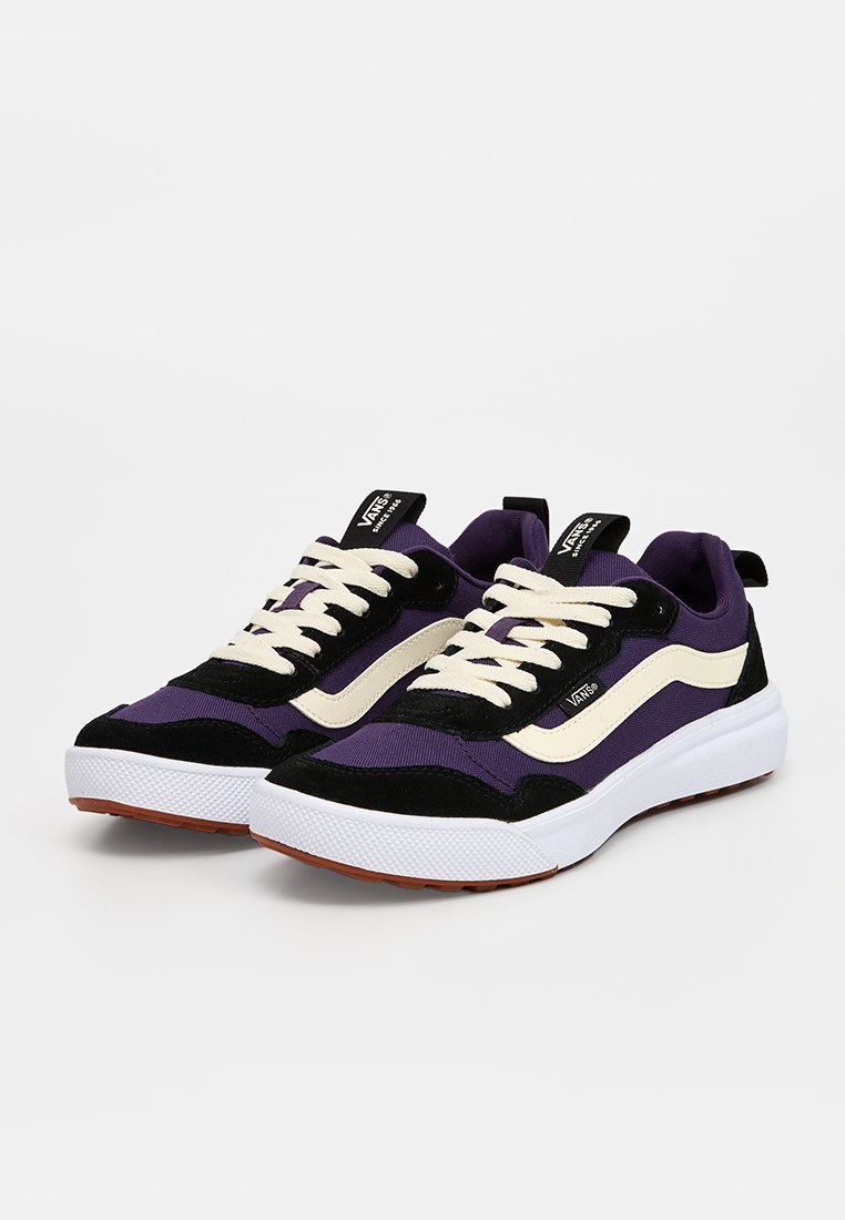 Lila und schwarze Sneakers mit weißen Akzenten, ausgestattet mit einem Obermaterial aus Wildleder und Mesh, dicken Schnürsenkeln und einer strukturierten Gummisohle.