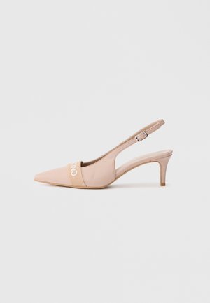 Beige pointed-toe slingback kitten heel with an adjustable buckle strap and elastic band across the front branded with white text.