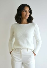 Biały, miękki sweter z długimi rękawami i okrągłym dekoltem, zestawiony z dopasowanymi białymi spodniami. Gładka faktura, minimalistyczny design.