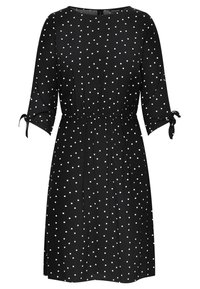Robe noire à pois blancs, manches trois-quarts, taille élastique et accents à nouer aux manches. Tissu doux et léger.