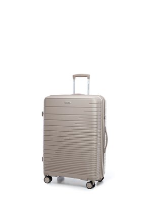 Beige harde koffer met horizontale ribbels, vier wielen, een uitschuifbaar handvat en een handvat aan de zijkant, rechtopstaand op een witte achtergrond.