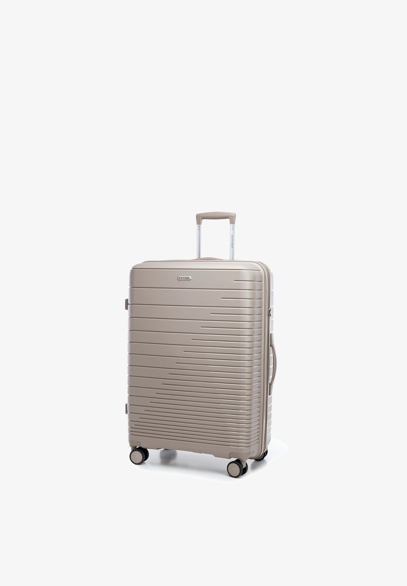Beige hard-shell suitcase with horizontal ridges, four wheels, retractable handle, and side handle standing upright on a white background.