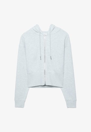 Svetlo siva skrajšana jopa z zadrgo, dolgimi rokavi, kapuco z vrvico ter rebrastimi manšetami in spodnjim robom, prikazana na belem ozadju.