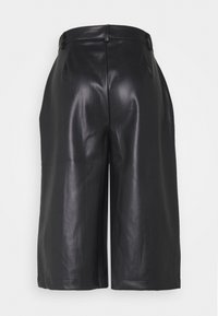 Svarta lädershorts med en slät yta, vida ben och en skräddarsydd passform. Har bälteshål i midjan och minimala sömmar.