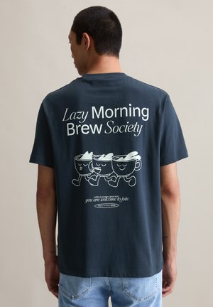 Donkerblauw katoenen T-shirt met speelse koffiemokgraphics en tekst: "Lazy Morning Brew Society." Zachte textuur, korte mouwen, relaxte pasvorm.