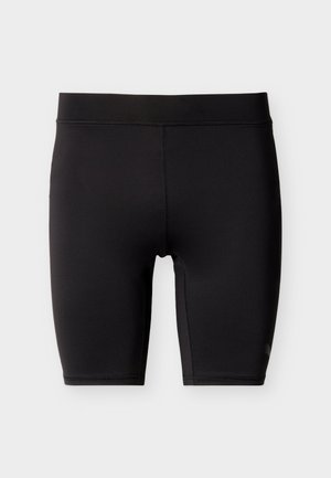Shorts de sport noirs, ajustés, longueur mi-cuisse, avec des coutures plates et une taille lisse, sur un fond clair uni.