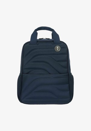 Zaino blu realizzato in tessuto testurizzato con un design a onde trapuntate, due manici superiori e una tasca laterale in rete. Dettaglio del logo circolare visibile.