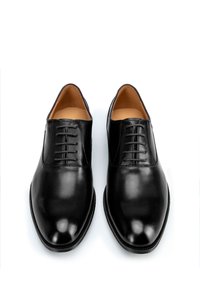 Zwarte leren gekleed schoenen met een gladde afwerking, puntschoenen en een vetersluiting met vijf oogjes. Binnenin gevoerd met tan leer.