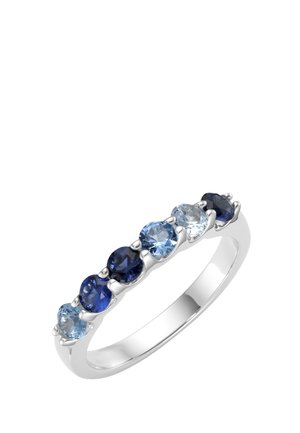 Silver ring set with seven round gemstones in varying shades of blue, arranged in a single row across the band.