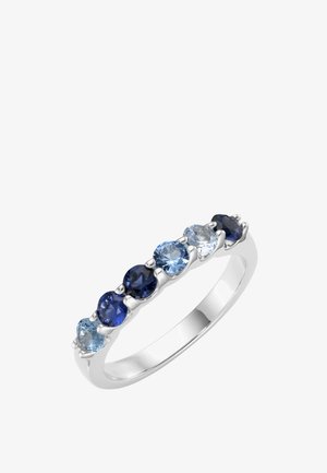Silberner Ring mit sieben runden Edelsteinen in verschiedenen Blautönen, die in einer einzigen Reihe über das Band angeordnet sind.