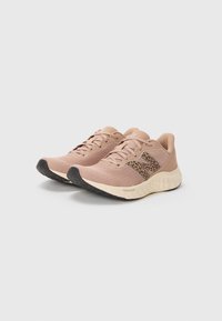 Light pink athletic shoes with a breathable mesh upper, black rubber outsole, and a textured brown accent on the sides.