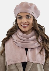 Set format din beret și eșarfă tricotate de culoare roz deschis. Textură moale, design clasic, cu margine ribbată pe beretă și eșarfă. Potrivit pentru vreme rece.