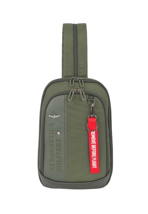 Borsa compatta a tracolla verde oliva con doppia cerniera, scritta "AERONAUTICA MILITARE", emblema alato e etichetta rossa "REMOVE BEFORE FLIGHT" attaccata.
