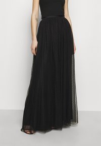 Czarna maksisuknia wykonana z lekkiego, przezroczystego materiału z teksturowanym wzorem kropek. Posiada pasek w talii w formie wstążki oraz luźny, zwiewny krój.