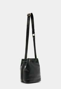 Zwarte leren emmerbag met een verstelbare schouderband en hardware in goudkleur. Voorzien van een trekkoordsluiting en een gestructureerde accent op de band.