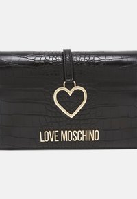 Černá kabelka z umělé kůže s krokodýlí texturou, zlatým srdíčkovým kováním a logem "LOVE MOSCHINO" v zlatém písmu na přední straně.