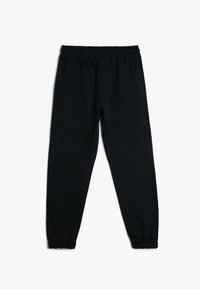 Pantalones deportivos negros con cinturilla elástica, puños ajustados y una textura suave y mate. Diseñados para la comodidad y facilidades de uso.