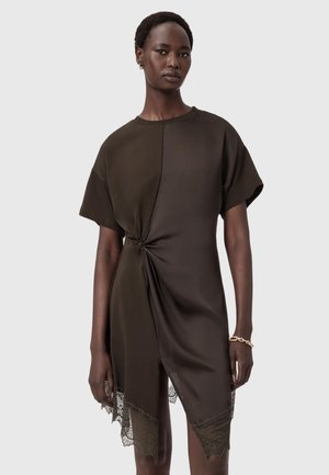 Mörkbrun klänning med korta ärmar, med en knutdetalj i midjan och spetsdetaljer vid fållen för ökad textur.