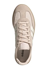 Zapatilla de ante y textil de color rosa claro con tres rayas blancas y cordones, cuenta con una plantilla texturizada y una suela de goma.