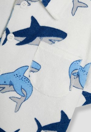 Camicetta bianca con motivi di squali blu; morbido tessuto in spugna; design con bottoni; tasca a toppa frontale; accenti blu multicolore.