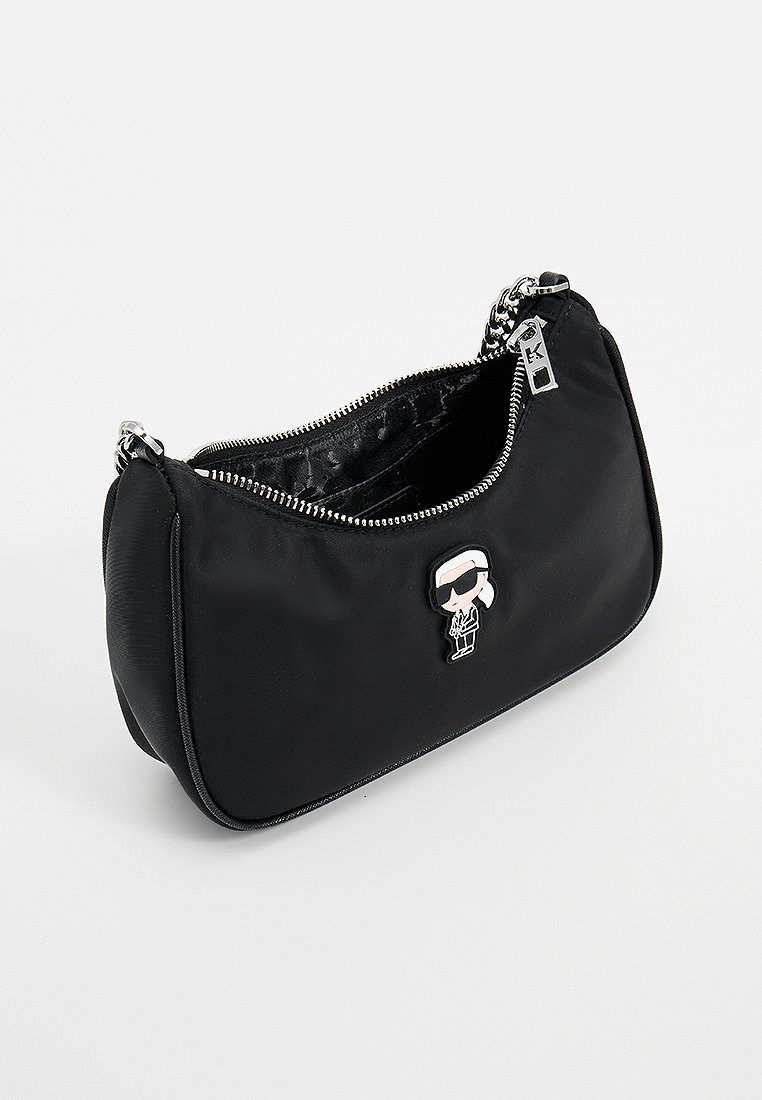 Sac à main en nylon noir avec des accessoires en acier inoxydable, forme incurvée, fermeture éclair, et une figure de dessin animé décorative attachée à l'avant.