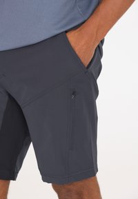 Laipion tummansiniset shortsit, jotka on valmistettu kevyestä kankaasta. Shortsien sivuilla on viisteetaskut ja reidessä vetoketjullinen tasku turvallista säilytystä varten.