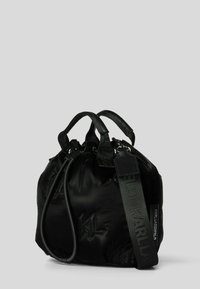 Czarna nylonowa torebka o zaokrąglonym kształcie, z podwójnymi uchwytami, odpinanym paskiem, subtelnym logo i gładką, błyszczącą fakturą.