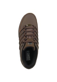 Scarpa sportiva marrone con superficie testurizzata, dotata di chiusure con lacci, diverse strisce, un collare imbottito e un sottopiede nero etichettato "K-Swiss."