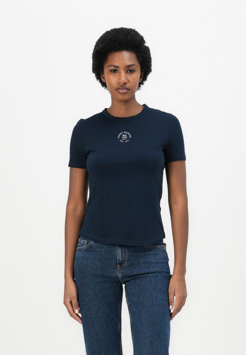 T-shirt bleu marine à manches courtes avec un col rond et un détail de logo sur la poitrine ; matériau en coton doux avec une coupe ajustée.