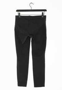 Svarta byxor i ett glatt och hållbart tyg. Har slim fit, två bakfickor och medelhög midja. Hänger från en krok.