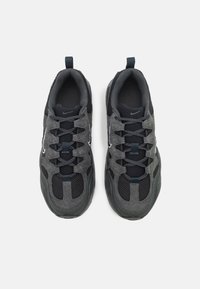 Paire de baskets de sport gris foncé et noir avec des détails en mesh et en daim, design à lacets et languettes au talon.