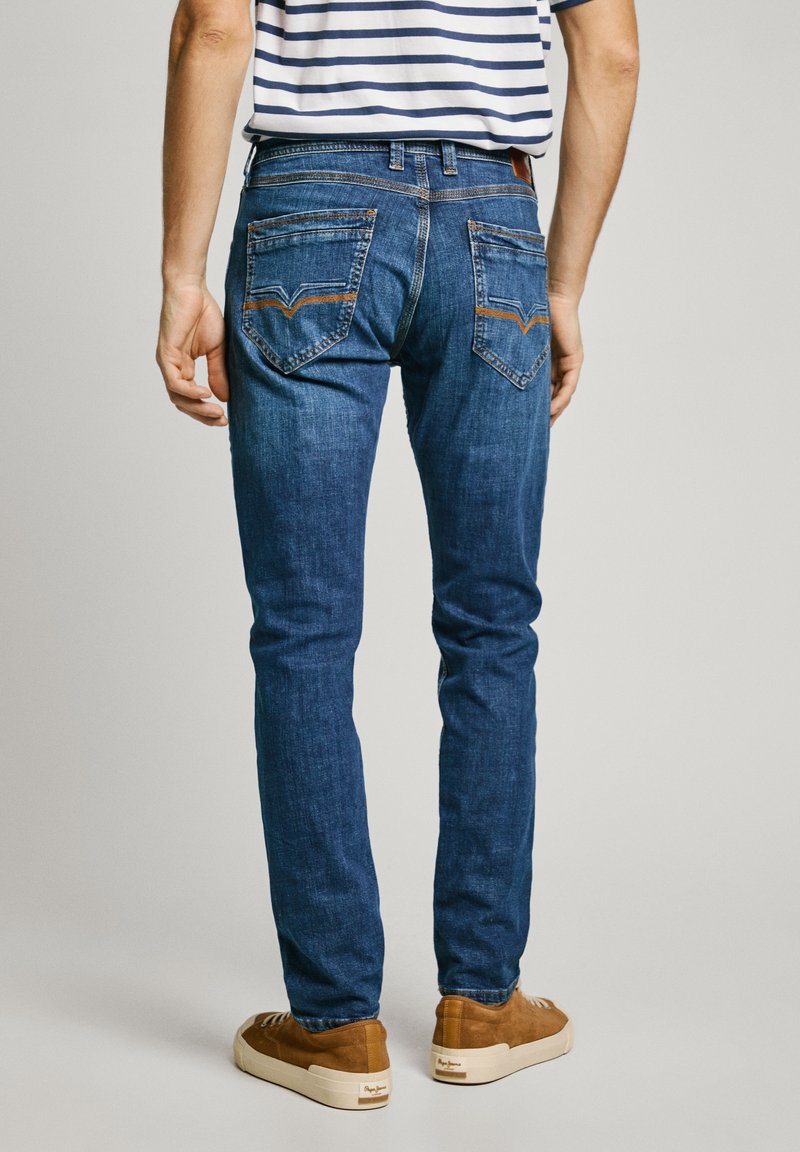 Herren blaue Denim-Jeans im Slim-Fit, mit zwei Gesäßtaschen mit auffälliger Steppnaht und einem Lederlabel am Bund.
