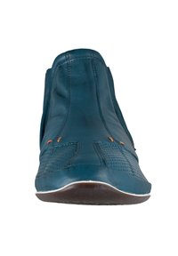 Teal läder sko med en slät yta, texturerade accenter, orangea sömmar och en rundad tå. Har en lågprofils-sula med subtil kurvatur.