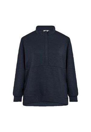 Tumedane sinine fliisiga pusa kõrge kraega, pikkade varrukatega ja esiotsa poolsiuguga. Sile tekstuur, mugav lõige ja õmbluste detailid.