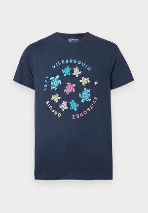 Granatowy T-shirt z wielokolorowymi żółwiami ułożonymi w okrąg wokół napisu "Vilebrequin À St-Tropez Depuis 1971" na przodzie.