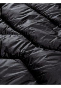 Tessuto di giacca a vento nera con una texture lucida e liscia. Presenta sezioni trapuntate e una finitura leggermente lucida. Design leggero e isolato.